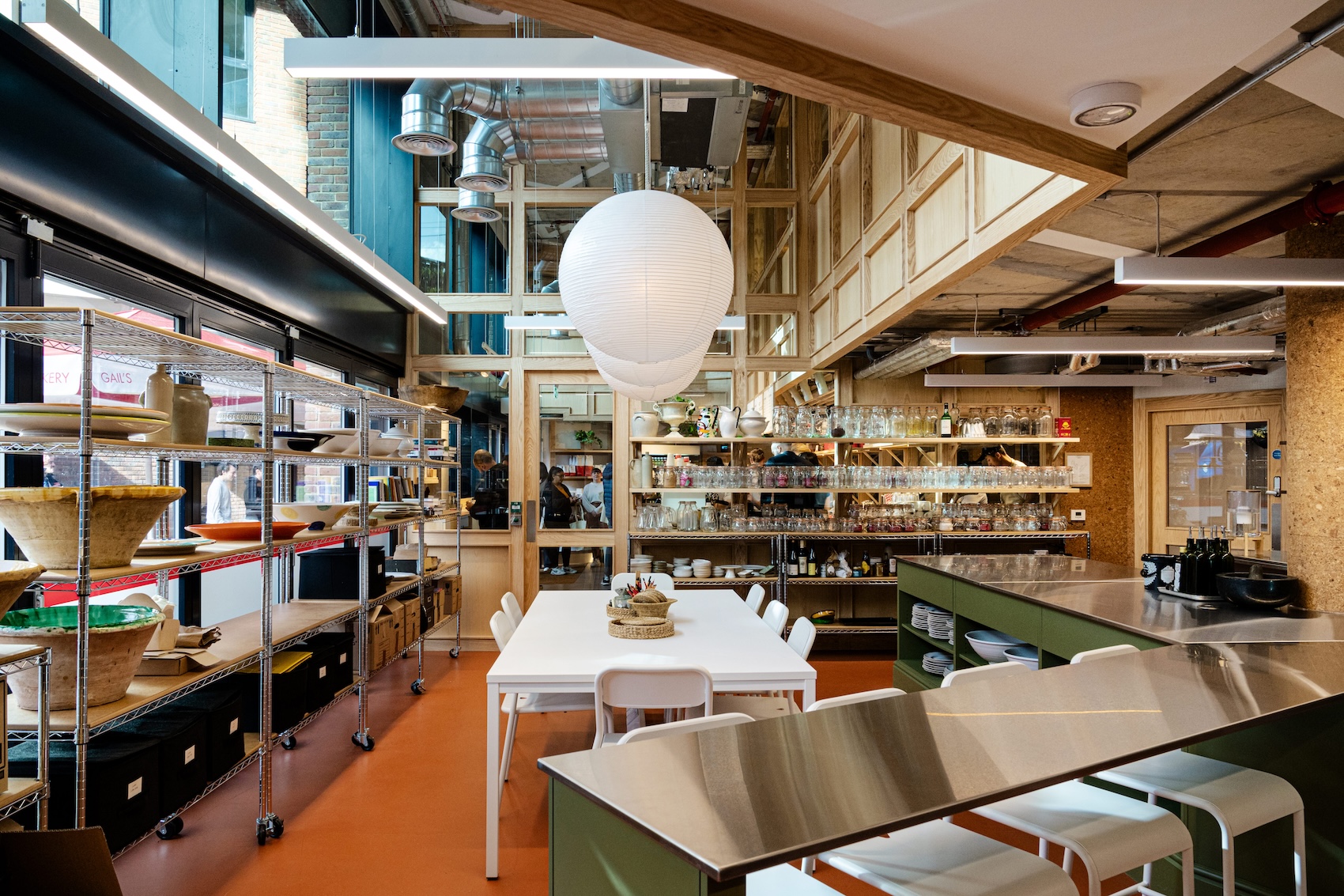 Kitchen with tables, shelves, and a large paper lantern.