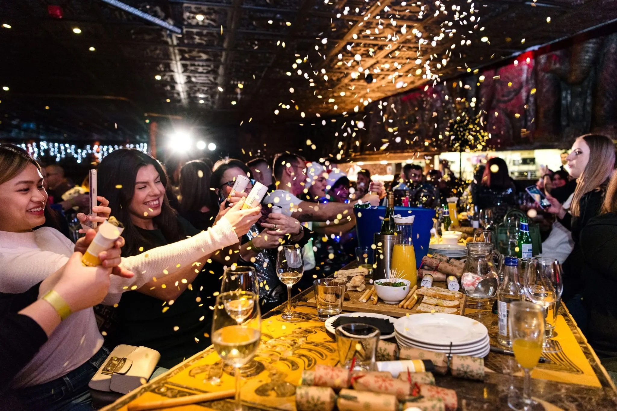 People celebrating with confetti, drinks, and food.