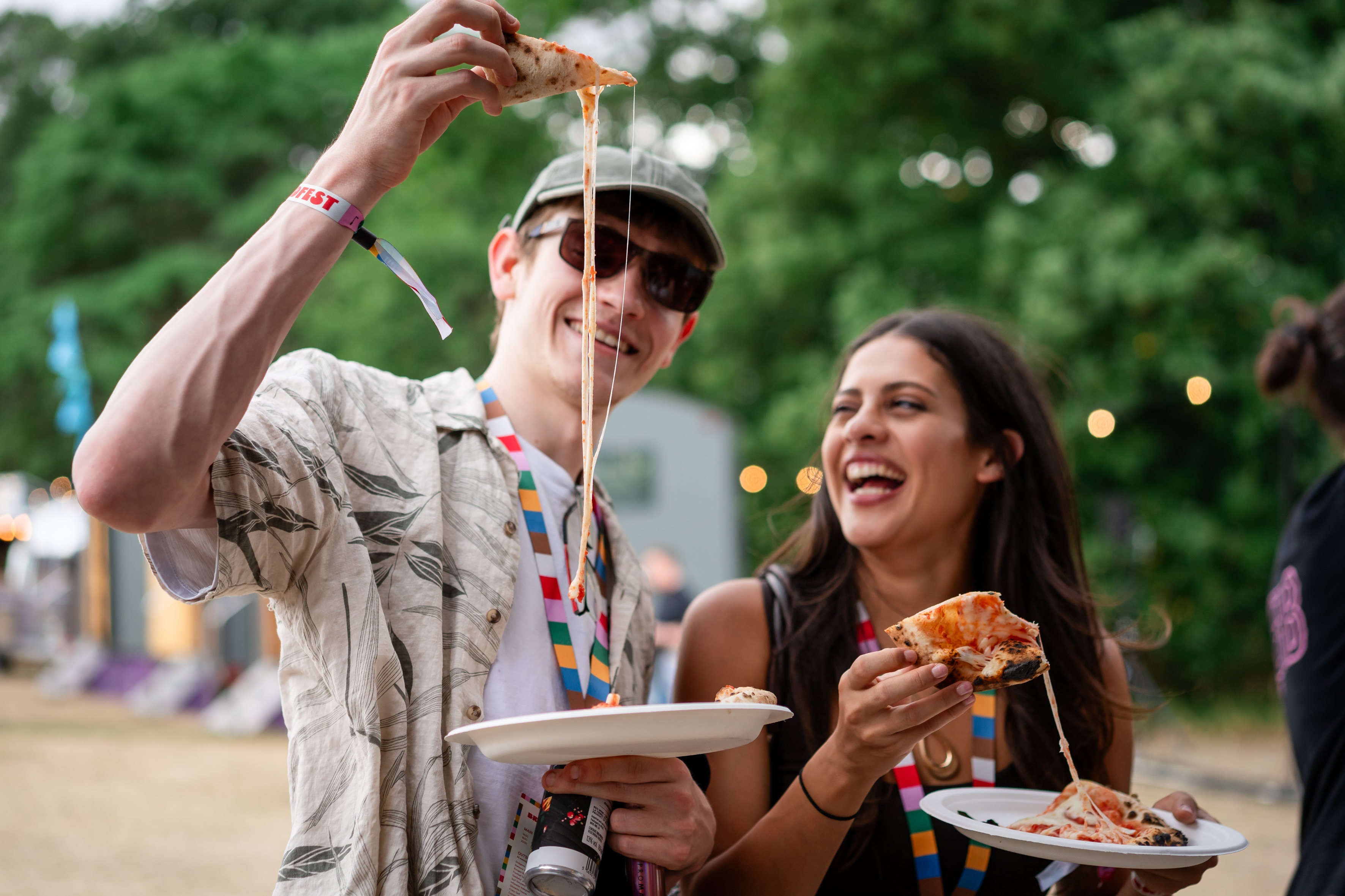 People enjoying pizza, with cheese stretching.