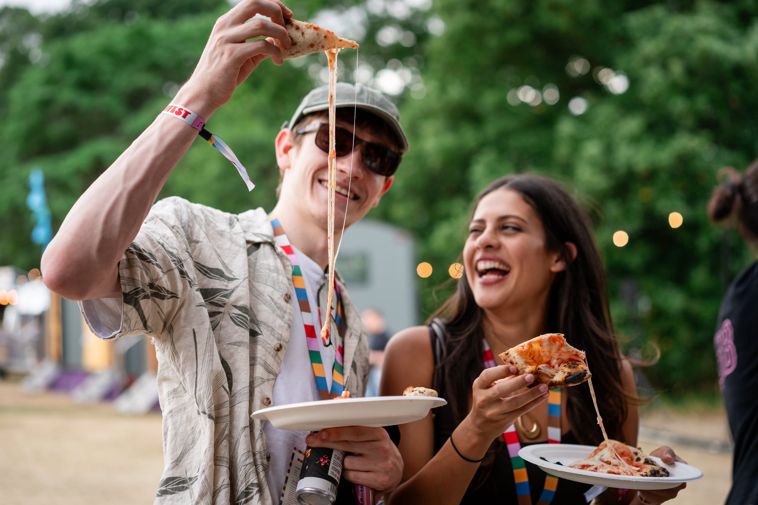 People enjoying pizza, with cheese stretching.