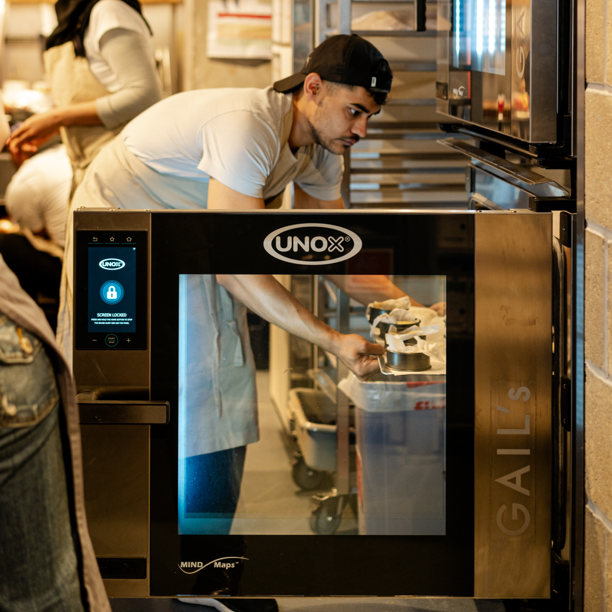 Workers using an oven in a bakery.