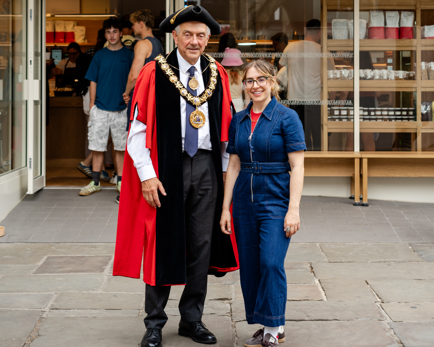 Mayor in robes with woman in denim jumpsuit.